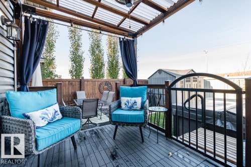 The property features an outdoor patio with a translucent roof, a wooden privacy fence, and dark wood decking - 3514 49 Avenue, Beaumont, AB - Outdoor With Deck Patio Veranda With Exterior