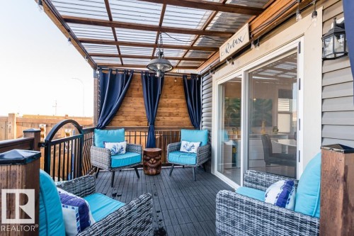 The property features an outdoor patio with a translucent roof cover and dark plank flooring - 3514 49 Avenue, Beaumont, AB - Outdoor With Deck Patio Veranda With Exterior