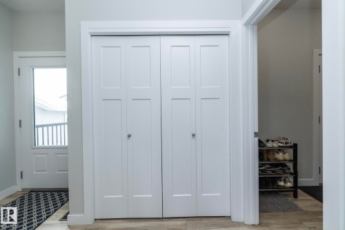 Entryway featuring white bi-fold doors, light-colored flooring, and a door with a window - 20650 94A Avenue, Edmonton, AB - Indoor Photo Showing Other Room