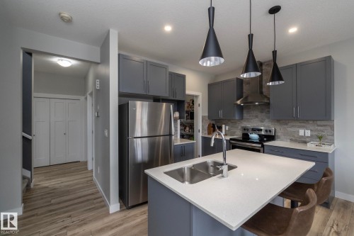 Modern kitchen with grey cabinetry, stainless steel appliances, and a light-colored countertop on the island - 20650 94A Avenue, Edmonton, AB - Indoor Photo Showing Kitchen With Double Sink With Upgraded Kitchen