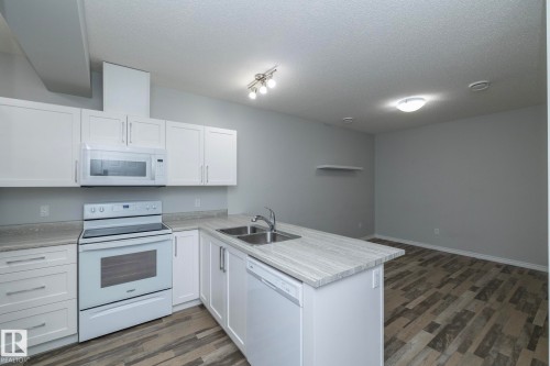 The kitchen features white cabinetry, a double basin sink, and a dishwasher - 20650 94A Avenue, Edmonton, AB - Indoor Photo Showing Kitchen With Double Sink