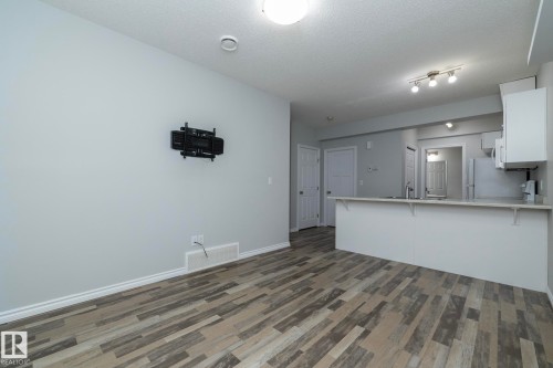 Open concept living area featuring wood-look flooring and light grey walls - 20650 94A Avenue, Edmonton, AB - Indoor Photo Showing Kitchen