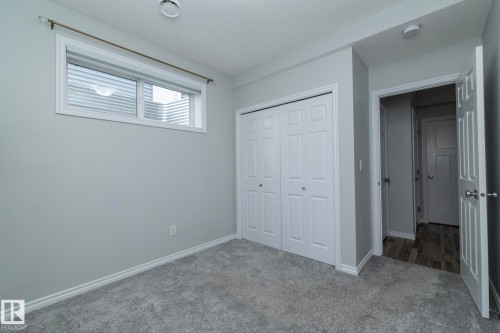 This room features light grey walls, grey carpeting, and a window with horizontal blinds - 20650 94A Avenue, Edmonton, AB - Indoor Photo Showing Other Room