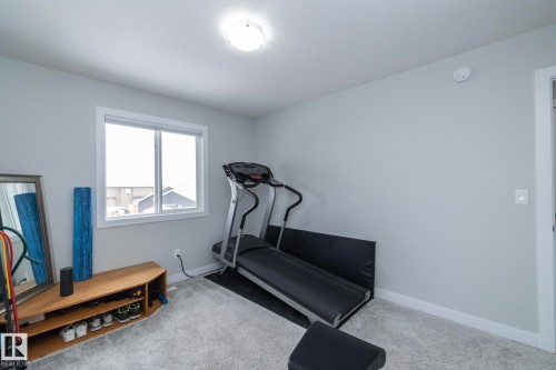 This versatile room features light gray walls, plush carpeting, and a window providing natural illumination - 20650 94A Avenue, Edmonton, AB - Indoor Photo Showing Gym Room