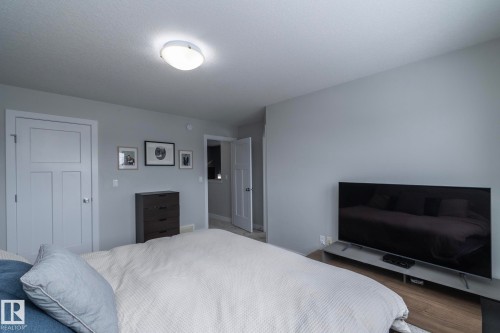 This bedroom features light gray walls, a ceiling-mounted light fixture, and wooden flooring - 20650 94A Avenue, Edmonton, AB - Indoor Photo Showing Bedroom