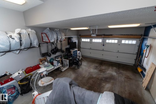 The property features an attached garage with a white overhead door, multiple windows, and overhead lighting - 20650 94A Avenue, Edmonton, AB - Indoor Photo Showing Garage