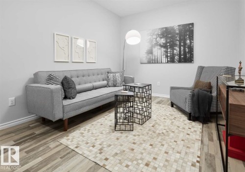 Living area featuring light wood-look flooring and a light-colored area rug - 20650 94A Avenue, Edmonton, AB - Indoor