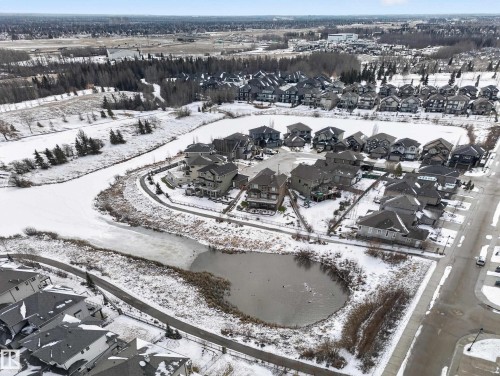 Aerial view of the community, showcasing residential properties bordering a frozen body of water and a paved pathway - 20650 94A Avenue, Edmonton, AB - Outdoor With View
