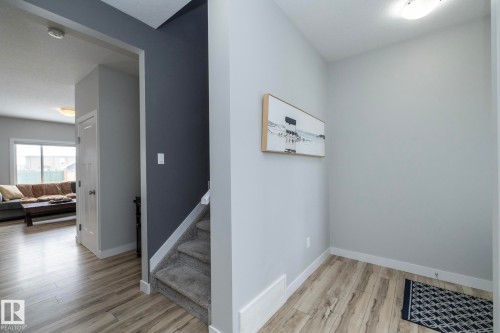 The property features light-toned wood-style flooring in the entryway and a carpeted staircase - 20650 94A Avenue, Edmonton, AB - Indoor Photo Showing Other Room