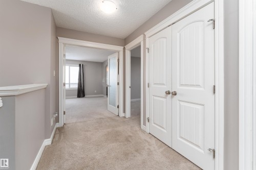 Hallway featuring light-colored carpet flooring, white trim, and white paneled doors - 149 Sutton Close, Sherwood Park, AB - Indoor Photo Showing Other Room