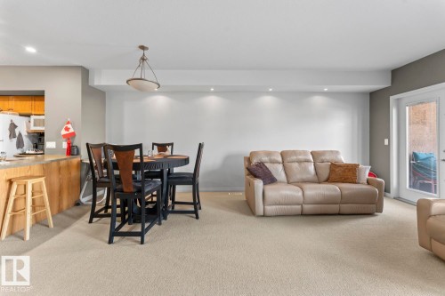 Spacious open concept living area featuring recessed lighting, a dining area with a round table and chairs, and a kitchen island with a light wood base - 107 801 11 Street, Cold Lake, AB - Indoor