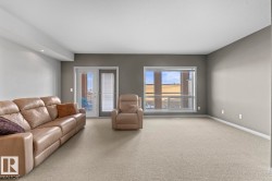 Living area featuring light-colored carpeting, a window providing natural light, and a double glass door leading to an outdoor space - 
