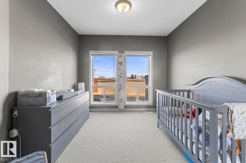 This room features two windows providing natural light, a ceiling-mounted light fixture, and carpeted flooring - 107 801 11 Street, Cold Lake, AB - Indoor Photo Showing Bedroom