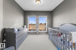This room features two windows providing natural light, a ceiling-mounted light fixture, and carpeted flooring - 