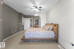 The property features a bedroom with carpeted flooring and a ceiling fan - 