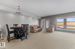 Spacious open-concept room featuring light-colored carpeting, large windows, and a glass-paneled door - 