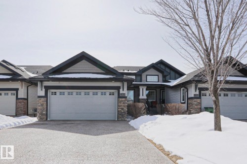 The property features a stone and siding exterior with a dark trim, a prominent front entrance, and an attached two-car garage - 2315 Ashcraft Cape, Edmonton, AB - Outdoor With Facade