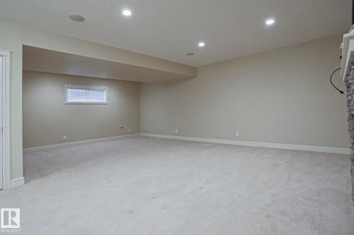 The property features an expansive carpeted room with recessed lighting and a window with blinds - 2315 Ashcraft Cape, Edmonton, AB - Indoor Photo Showing Basement