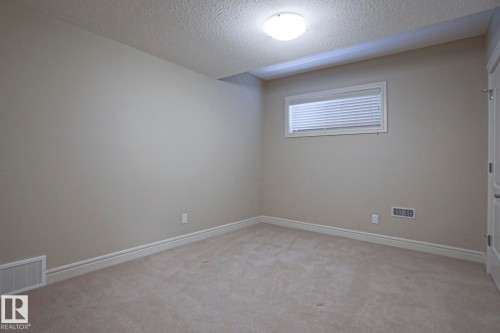 This room features light-colored carpeting, neutral painted walls, and a window with blinds - 2315 Ashcraft Cape, Edmonton, AB - Indoor Photo Showing Other Room