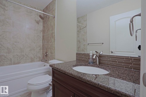 The bathroom features a vanity with a granite countertop and an under-mount sink - 2315 Ashcraft Cape, Edmonton, AB - Indoor Photo Showing Bathroom