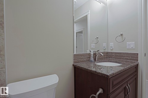 Bathroom vanity with granite countertop, integrated sink, and modern faucet - 2315 Ashcraft Cape, Edmonton, AB - Indoor Photo Showing Bathroom