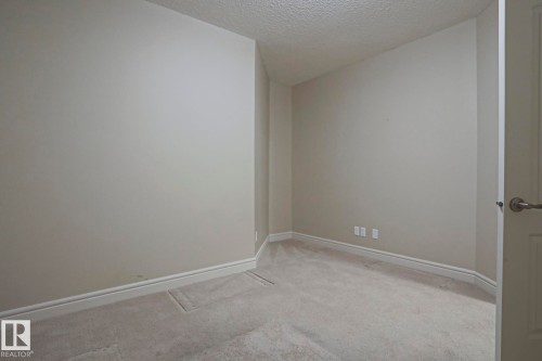 This room features light-colored walls, carpeted flooring, and white baseboards - 2315 Ashcraft Cape, Edmonton, AB - Indoor Photo Showing Other Room