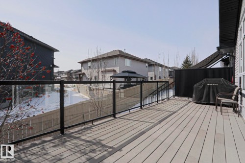 The property features an outdoor deck with composite decking, glass panel railings, and a privacy screen - 2315 Ashcraft Cape, Edmonton, AB - Outdoor With Exterior