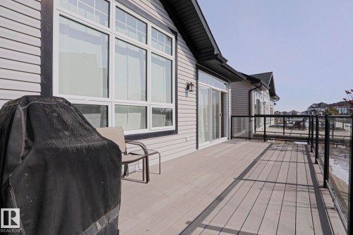 The property features a spacious rear deck with composite decking and glass panel railings, providing an outdoor living area - 2315 Ashcraft Cape, Edmonton, AB - Outdoor With Exterior