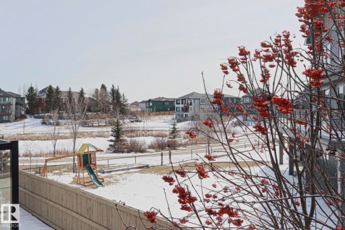 This property offers a view of a community area, featuring a wooden playground with a slide and swing set, and a walking path - 2315 Ashcraft Cape, Edmonton, AB - Outdoor