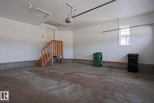 Spacious garage with a concrete floor, white walls, and a window providing natural light - 2315 Ashcraft Cape, Edmonton, AB - Indoor Photo Showing Garage