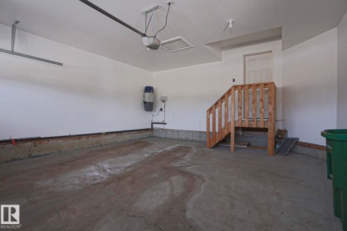 This spacious garage features a concrete floor, white painted walls, and an overhead door opener mechanism - 2315 Ashcraft Cape, Edmonton, AB - Indoor Photo Showing Garage
