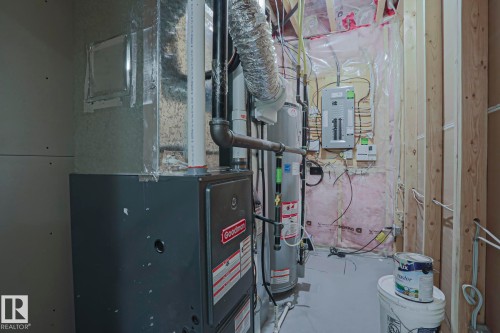 The property is equipped with a furnace and water heater, visible alongside exposed electrical panels and wiring - 2315 Ashcraft Cape, Edmonton, AB - Indoor