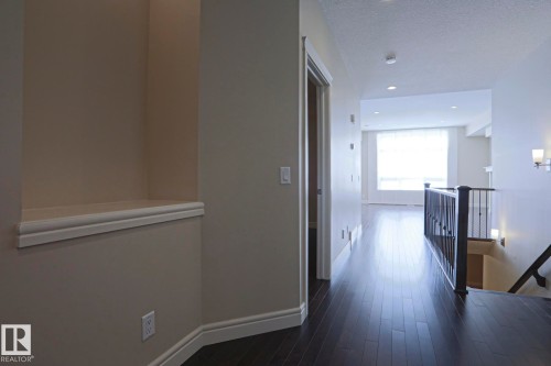 Hallway featuring dark hardwood flooring, recessed lighting, and a built-in wall niche - 2315 Ashcraft Cape, Edmonton, AB - Indoor Photo Showing Other Room