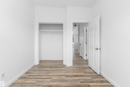 This space features light-colored plank flooring and white walls, creating a bright and airy atmosphere - 6103-6105 97A Avenue, Edmonton, AB - Indoor Photo Showing Other Room
