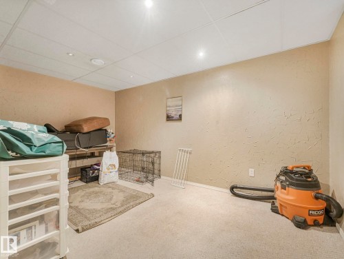 The property features neutral-toned carpeted flooring, textured walls, and a white suspended ceiling with recessed lighting - 4105 41 Avenue, Edmonton, AB - Indoor