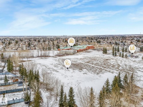 Expansive aerial view of the property and its surrounding area, featuring open land, scattered trees, and distant urban development under a clear sky - 4105 41 Avenue, Edmonton, AB - Outdoor With View
