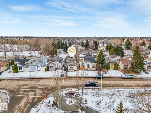 Aerial view showcasing the property within a residential setting, featuring nearby houses, mature trees, and open land - 4105 41 Avenue, Edmonton, AB - Outdoor With View