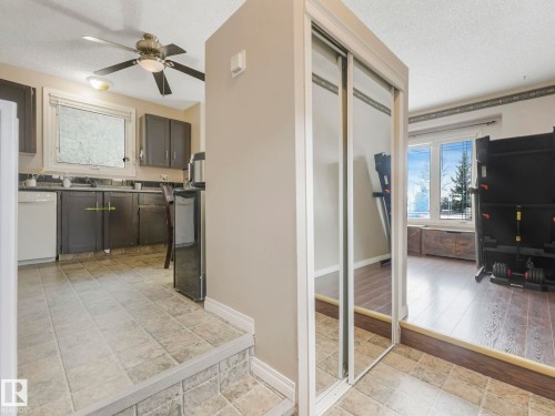 The property features a kitchen with tile flooring, dark cabinetry, and white appliances - 4105 41 Avenue, Edmonton, AB - Indoor Photo Showing Other Room