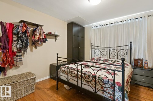 Bedroom featuring hardwood floors and a window with white curtains - 15926 92 Avenue, Edmonton, AB - Indoor Photo Showing Bedroom
