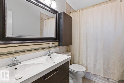 Bathroom featuring a double vanity with two sinks, a framed mirror, and a toilet - 15926 92 Avenue, Edmonton, AB - Indoor Photo Showing Bathroom