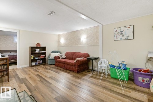 This room features wood-look flooring and light-colored walls - 15926 92 Avenue, Edmonton, AB - Indoor Photo Showing Living Room