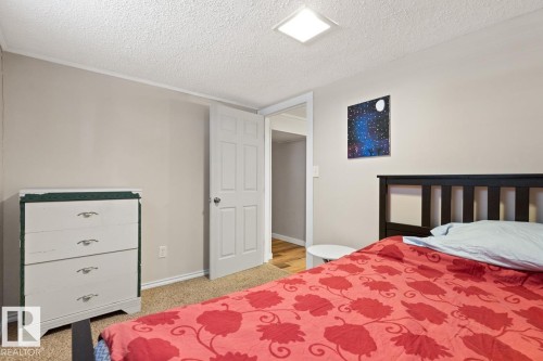 This room features neutral-toned walls, a textured ceiling, and carpeted flooring - 15926 92 Avenue, Edmonton, AB - Indoor Photo Showing Bedroom