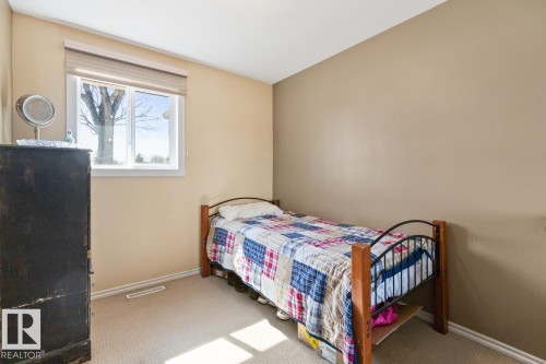 This room features a window providing natural light, warm-toned walls, and carpeting - 15926 92 Avenue, Edmonton, AB - Indoor Photo Showing Bedroom