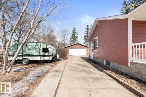 The property features a concrete driveway leading to a detached garage - 15926 92 Avenue, Edmonton, AB - Outdoor