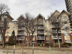 The property features an exterior with brick and stucco finishing, balconies with white railings, and gabled rooflines - 
