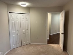 Room featuring bi-fold closet doors, neutral-toned carpeting, and a flush mount ceiling light - 