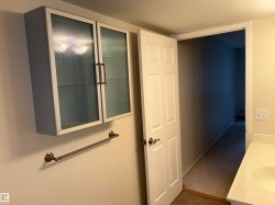 Wall-mounted cabinetry with frosted glass inserts and bronze-finish hardware - 