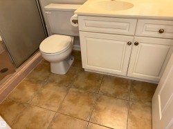 Bathroom vanity with an integrated sink, cream-toned cabinetry, and bronze-finish hardware - 