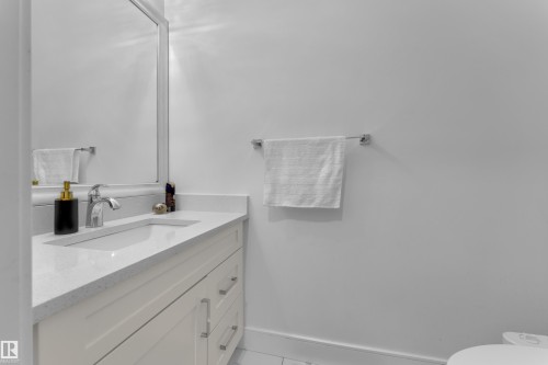 Vanity with an integrated sink and a framed mirror - 2630 16A Ave Nw, Edmonton, AB - Indoor Photo Showing Bathroom