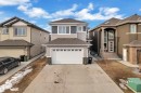 The property features a two-story design with light-toned siding and dark grey accents, a two-car garage, and a concrete driveway - 2630 16A Ave Nw, Edmonton, AB  - Outdoor 